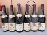 six bouteilles de vin sont alignées en rang devant une boîte en carton