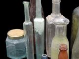 many different colored glass bottles sitting on a black surface