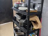 une étagère noire sur laquelle sont posées des casseroles et des poêles