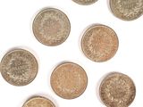 six pièces de monnaie britanniques différentes sont disposées en cercle sur une surface blanche