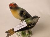 a small figurine of a bird with a tag on it ' s neck