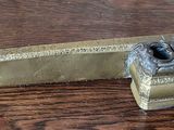 a small brass object on a wooden table