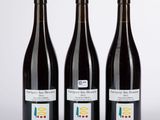 trois bouteilles de vin posées l'une à côté de l'autre sur une table