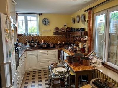 une cuisine avec un sol en damier et des murs jaunes
