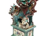 a statue of a dragon sitting on top of a box