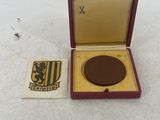 a small box with a medal in it on a white surface
