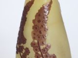 a yellow glass vase with a brown design on it