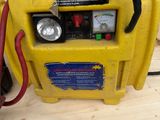 an image of a yellow air compressor sitting on top of a wooden floor