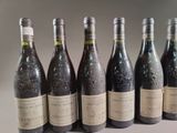 six bottles of wine are lined up in a row on a table