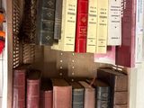 de nombreux livres anciens dans une boîte posée sur une étagère