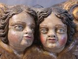 two statues of angels that are sitting on a bench