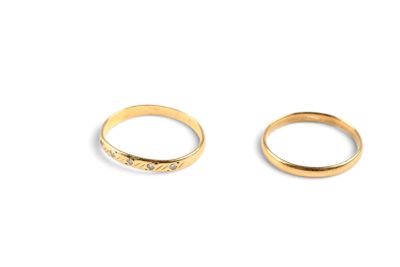 two gold wedding rings on a white background