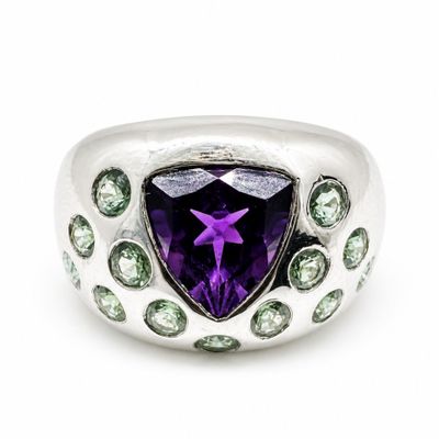 an image of a ring with a purple amethorate surrounded by green and white stones
