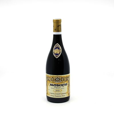 the bottle of wine is sitting on a white surface