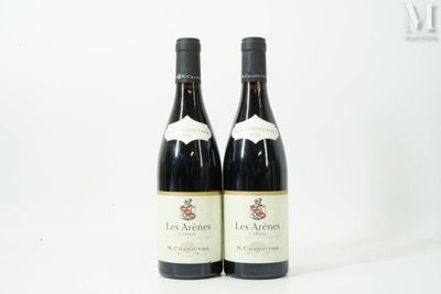 two bottles of red wine sitting on top of a white table
