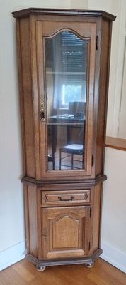 un meuble en bois avec une porte en verre dans une pièce