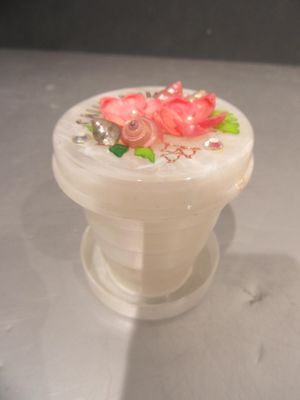 un petit vase blanc orné de fleurs roses