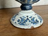 a blue and white vase sitting on a wooden table