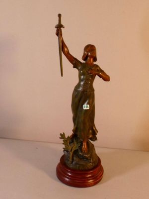 une statue représentant une femme tenant une épée, posée sur une table