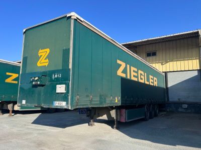 deux semi-remorques garées devant un immeuble