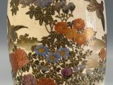 an oriental vase with a bird and flowers design on it