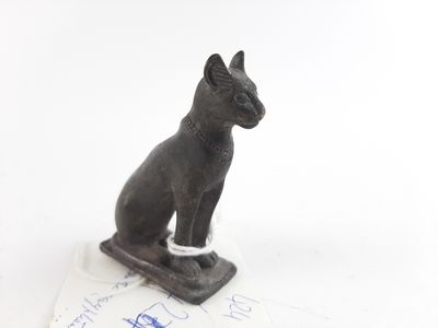a statue of a cat sitting on top of a piece of paper