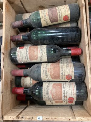 Plusieurs bouteilles de vin se trouvent dans une caisse en bois posée sur une étagère
