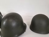 three helmets are lined up on a white surface