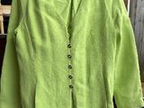 une veste vert citron suspendue à un cintre devant une fenêtre
