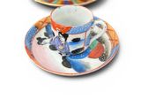 two cups and saucers sitting on a white surface