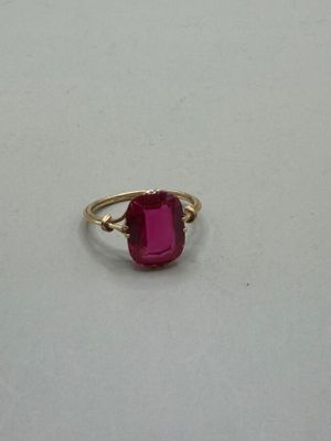 a close up of a ring with a pink stone on it