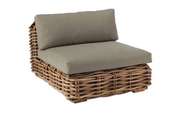 un gros plan d'une chaise en osier sur laquelle est posé un coussin
