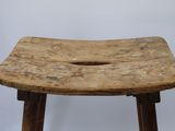 an old wooden stool with a hole in the middle of it