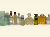 many different types of perfume bottles lined up on a white surface