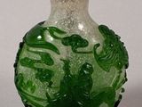 a green and white glass bottle with a red lid
