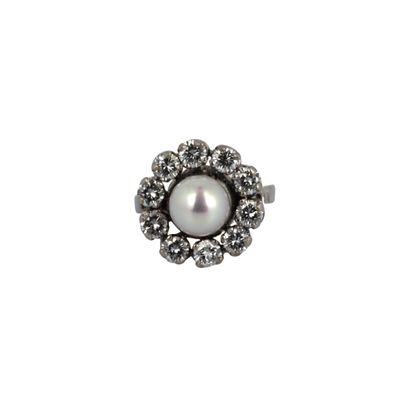 gros plan d'une bague en perles et diamants sur fond blanc
