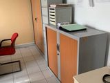 a room with a desk, cabinets, and a chair in it