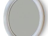 un miroir rond avec un cadre blanc accroché au mur