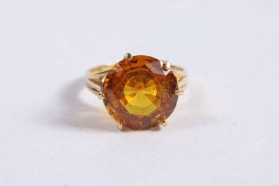 Gros plan sur une bague contenant une pierre orange