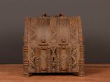a small wooden chest on a table with a black background