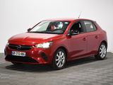 une voiture rouge est garée dans une pièce au sol en damier