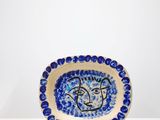 assiette en céramique bleue et blanche ornée d'un visage