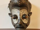 un masque noir et blanc posé sur une table en bois
