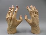 pair of hands made out of clay on a gray background