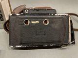 a black camera sitting on a table next to a book