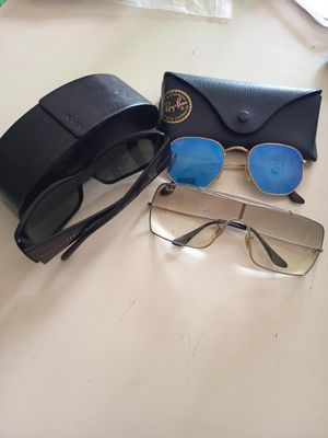 une paire de lunettes de soleil et un étui à lunettes posés sur une table à côté d'une paire de lunettes de vue