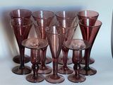 six verres à vin posés sur une table, à côté d'un vase