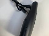 a black blow dryer sitting on a table next to a bottle of liquid