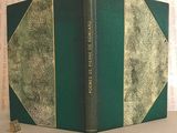 an old book with a green cover sitting on a table