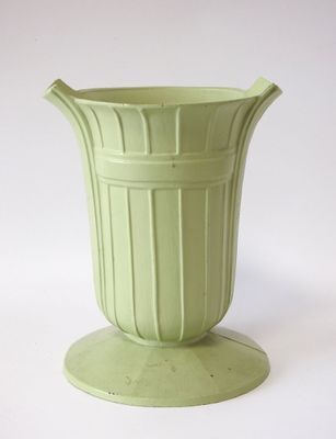 un vase vert posé sur une table blanche